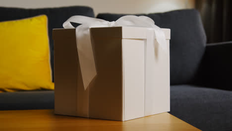 Nahaufnahme-Eines-Als-Geschenk-Verpackten-Geschenks-Mit-Schleife-Auf-Dem-Tisch-Im-Wohnzimmer-Zu-Hause